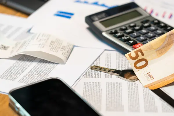 Calculadora y billete de euro sobre documentos