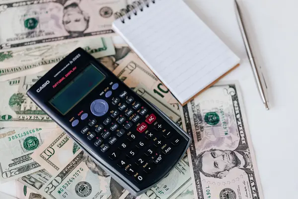 Calculadora y bloc de notas sobre billetes