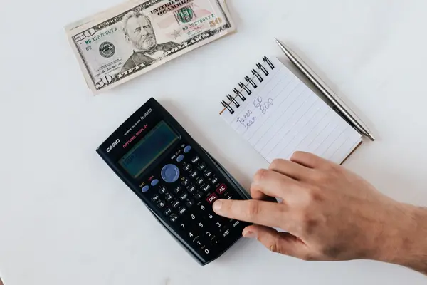 Manos haciendo cuentas con calculadora
