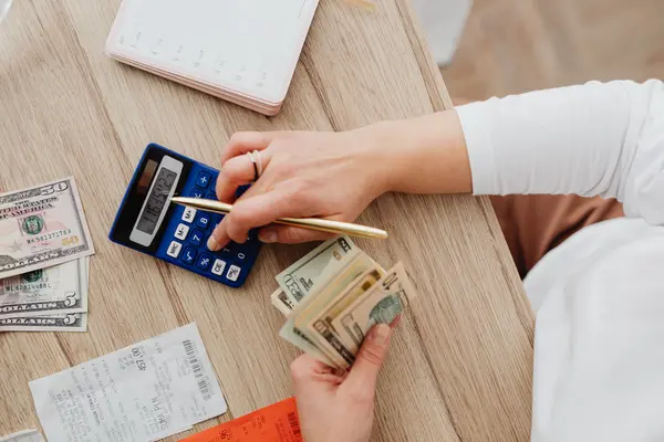 Persona con calculadora y billetes